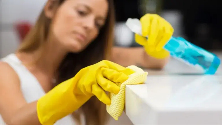 Woman wiping surface with spray