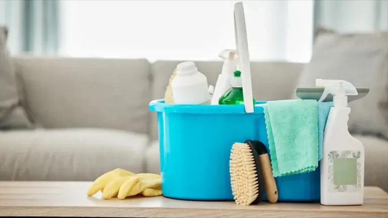blue bucket with cleaning supplies on table