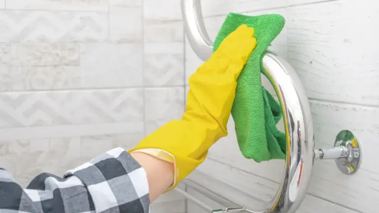 Deep cleaning chrome towel rail in bathroom