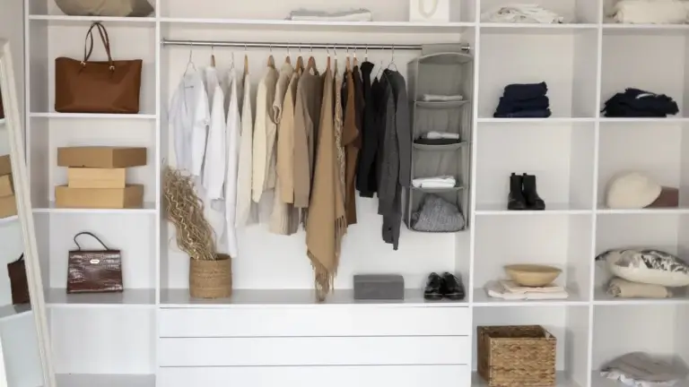 Organized open wardrobe with neutral-tone clothing and accessories